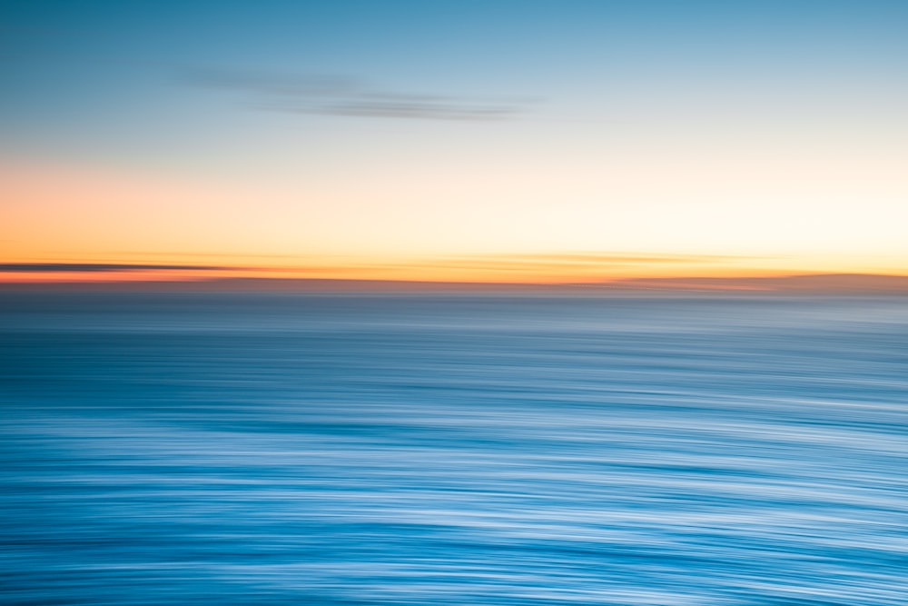 a blurry photo of the ocean at sunset