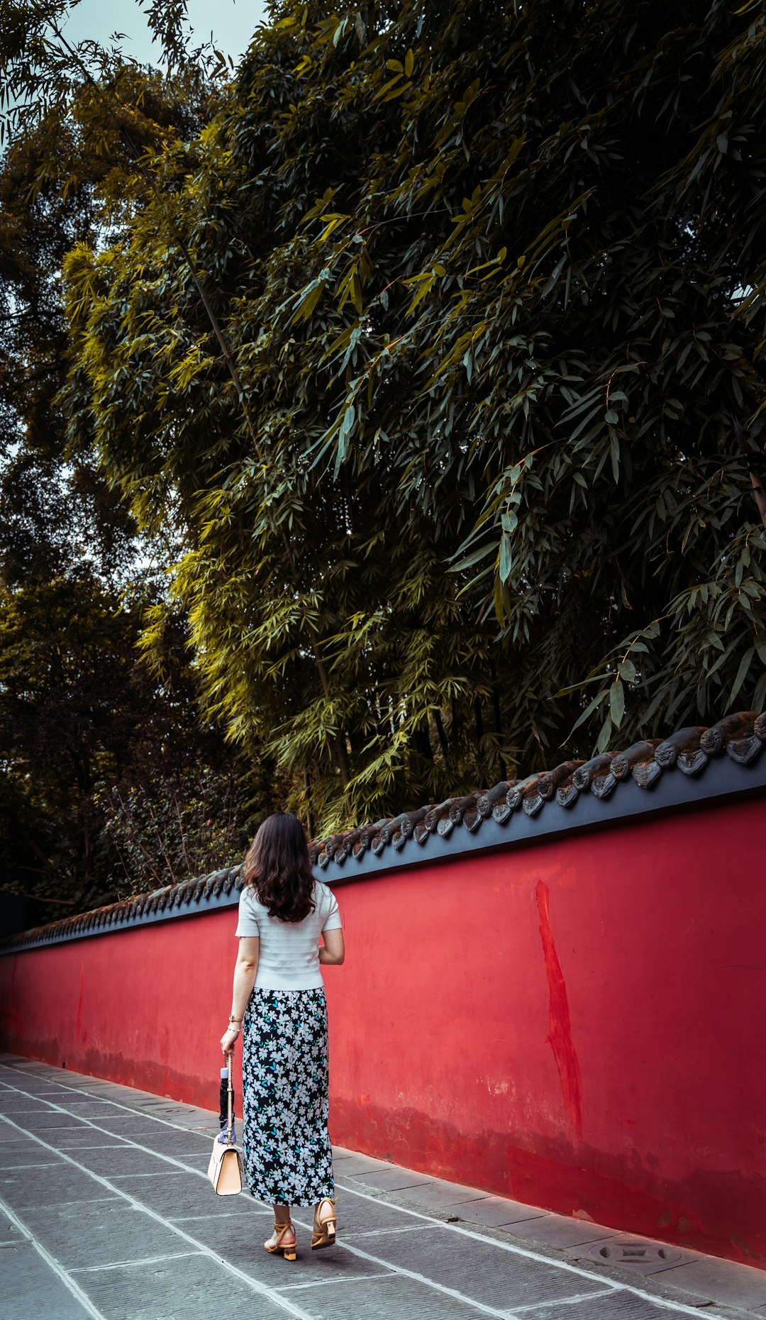 woman in white shirt standing on red roof
