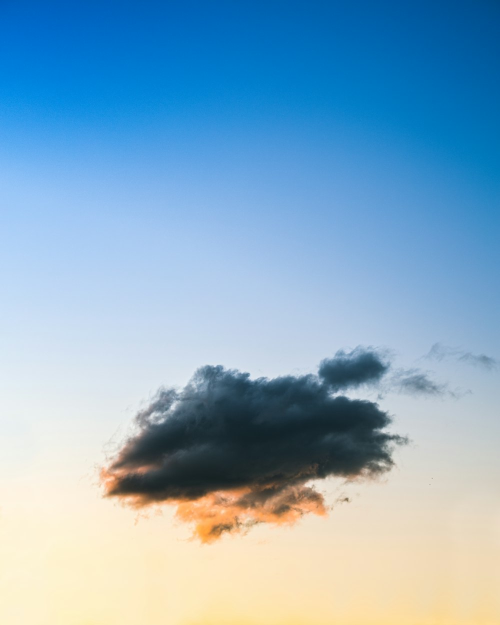 a plane flying in the sky at sunset