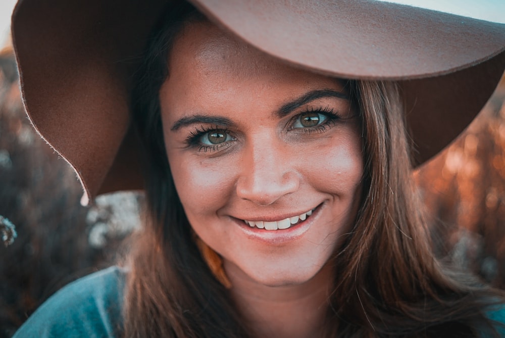 smiling woman in blue shirt wearing white hat