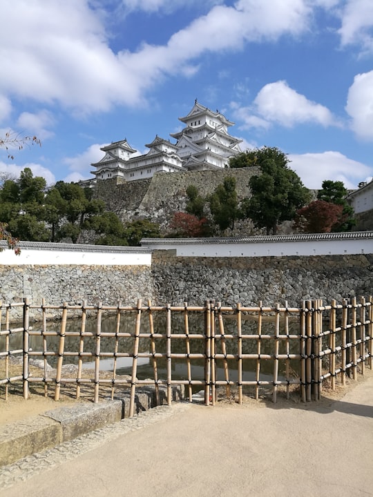 brown wooden fence on beach shore during daytime in Himeji Castle Japan