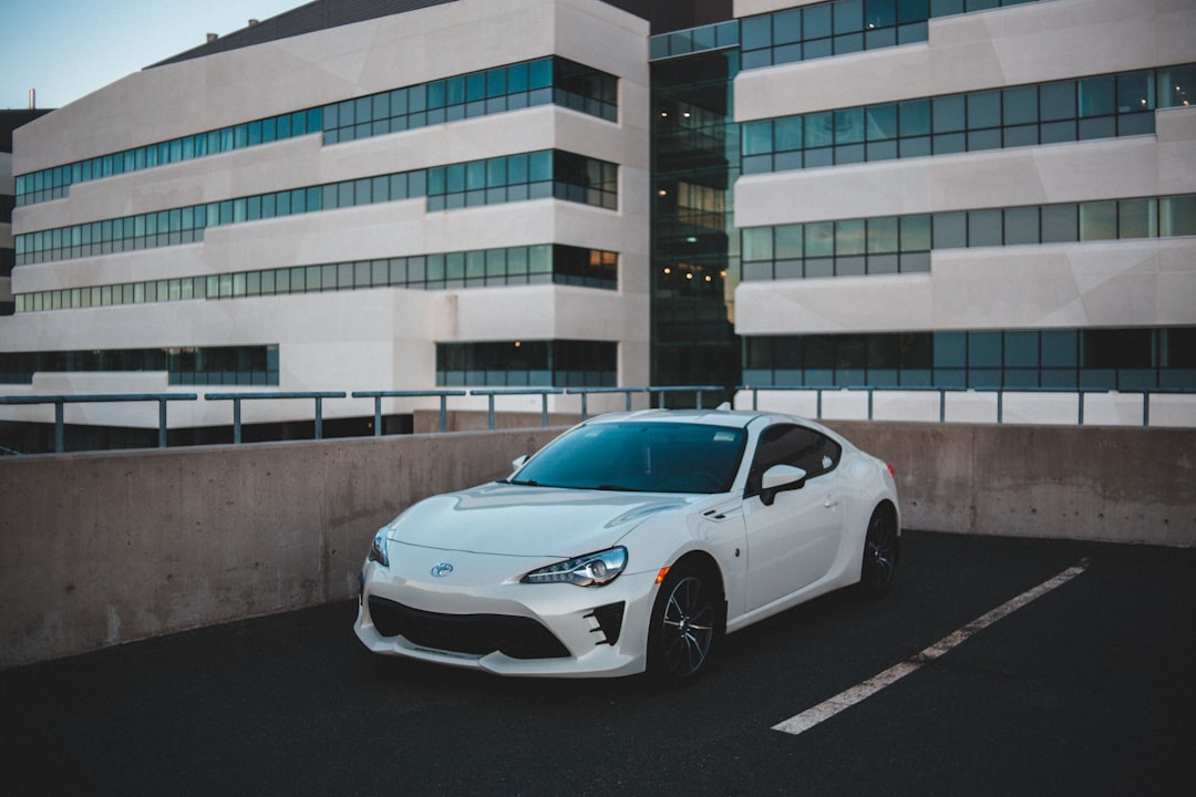 white bmw m 3 coupe parked near white concrete building during daytime