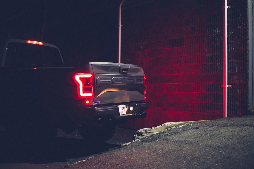 black chevrolet car parked beside red wall