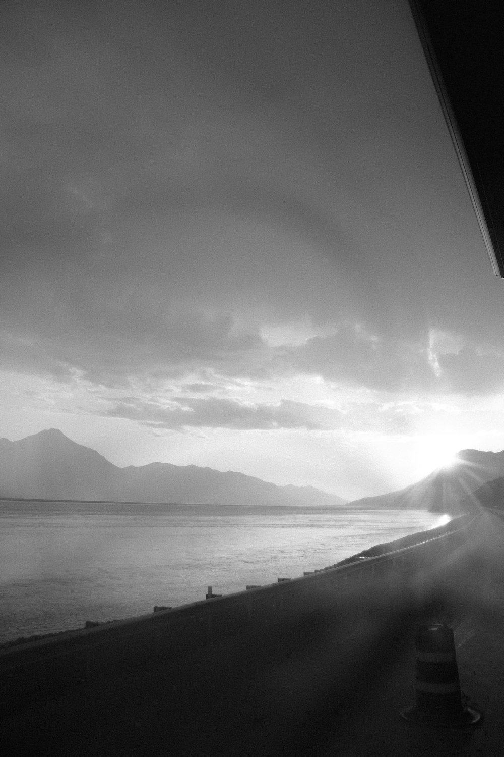 grayscale photo of mountains near body of water