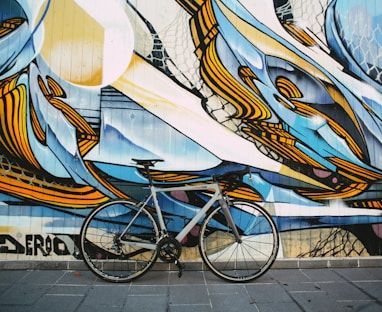blue city bike parked beside white blue and brown wall