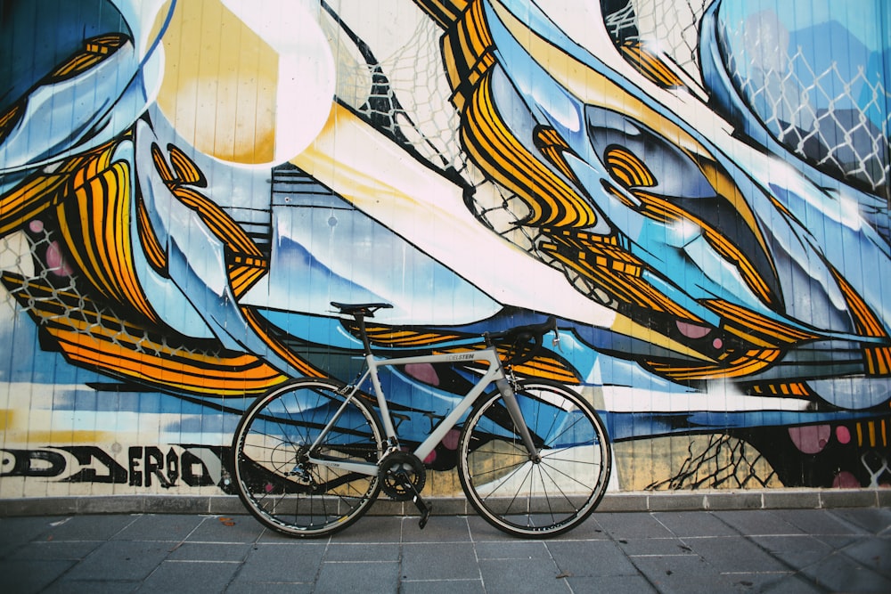 blue city bike parked beside white blue and brown wall