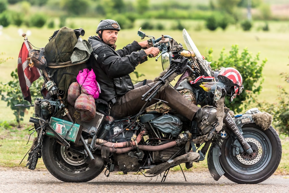 man in black leather jacket riding on black motorcycle during daytime