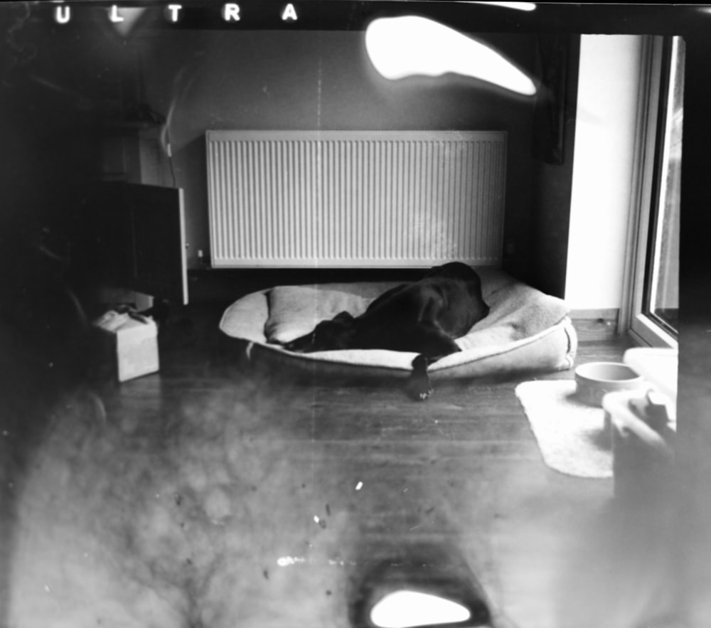 grayscale photo of man lying on bed