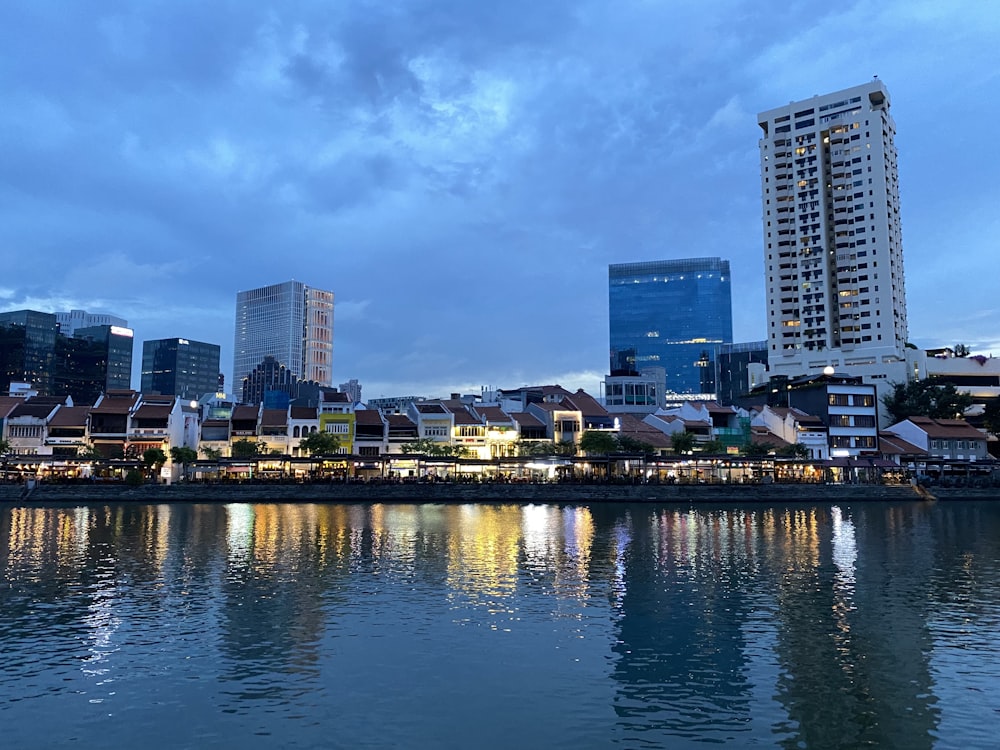 city skyline across body of water during night time