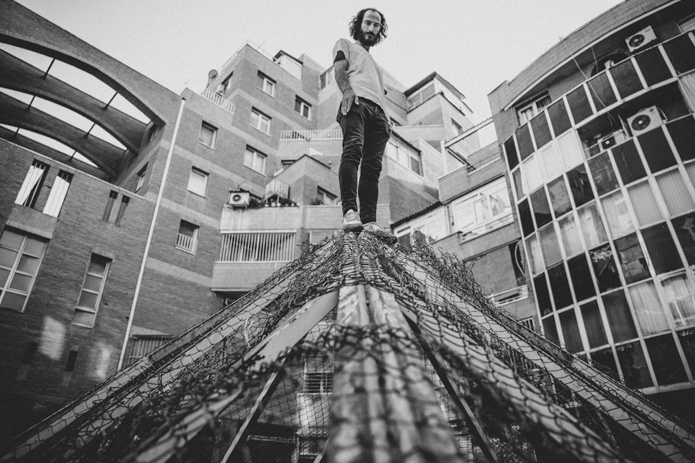 grayscale photo of woman in white long sleeve shirt and black skirt standing on stairs