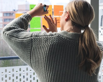 woman in gray sweater holding smartphone