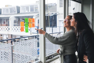Two businesswomen discussing investment strategies in a bright office.