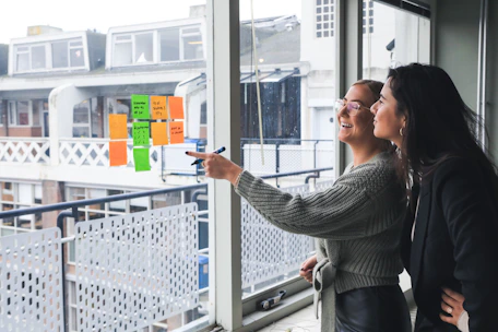 Two businesswomen discussing investment strategies in a bright office.