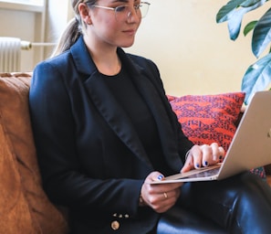 woman in black blazer using macbook