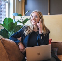 woman in blue long sleeve shirt using silver macbook