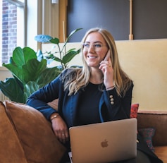 woman in blue long sleeve shirt using silver macbook