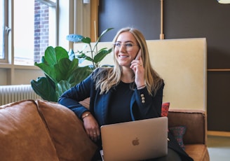 woman in blue long sleeve shirt using silver macbook