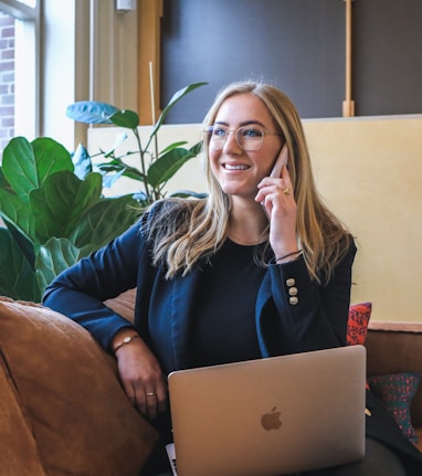 woman in blue long sleeve shirt using silver macbook