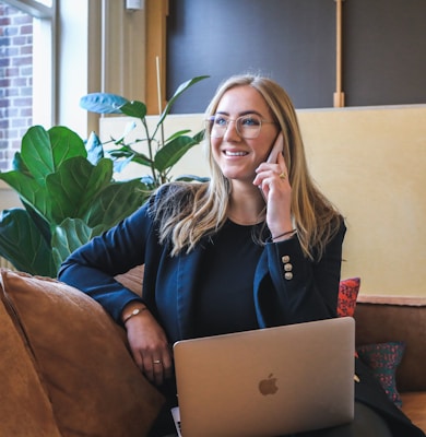 woman in blue long sleeve shirt using silver macbook