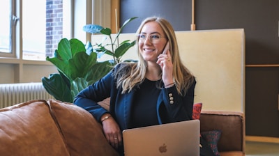 woman in blue long sleeve shirt using silver macbook