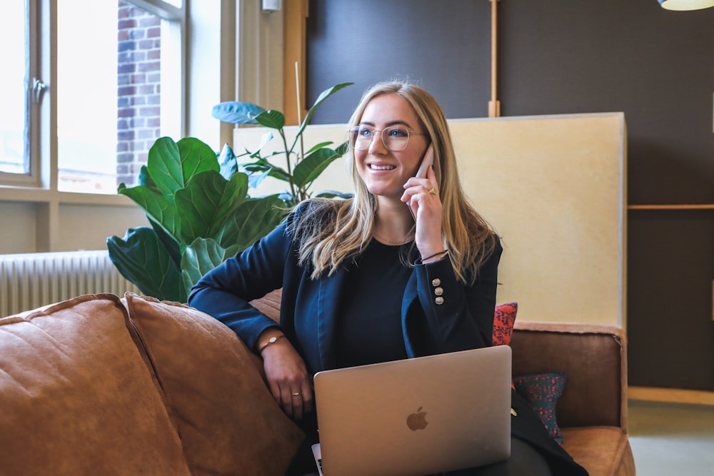 Frau im blauen Langarmshirt mit silbernem MacBook