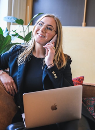 woman in blue long sleeve shirt sitting on brown couch