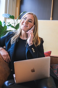 woman in blue long sleeve shirt sitting on brown couch