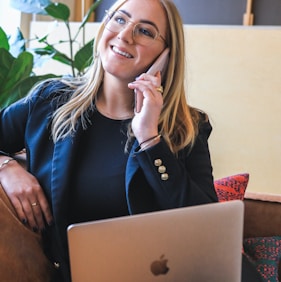 woman in blue long sleeve shirt sitting on brown couch