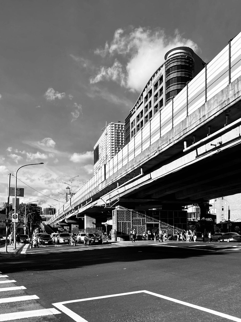 grayscale photo of cars on road near building