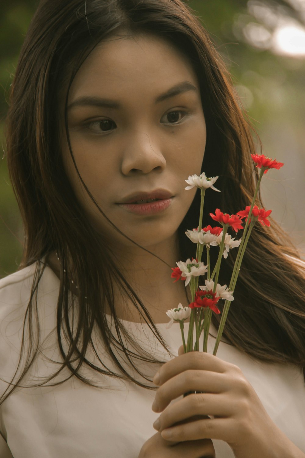 woman holding white and red flowers