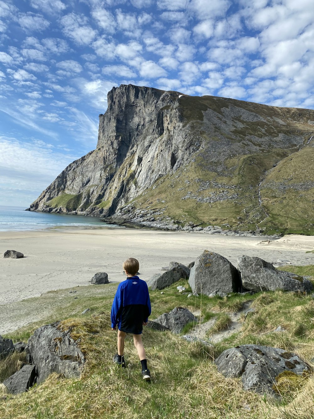 woman in blue shirt standing on seashore during daytime