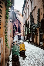 yellow and black motor scooter parked beside brown concrete building during daytime