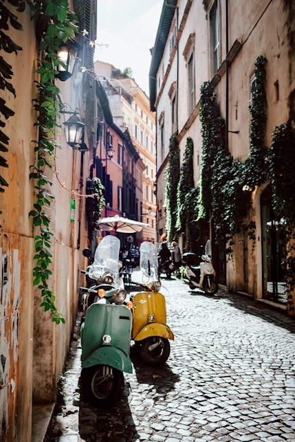 yellow and black motor scooter parked beside brown concrete building during daytime