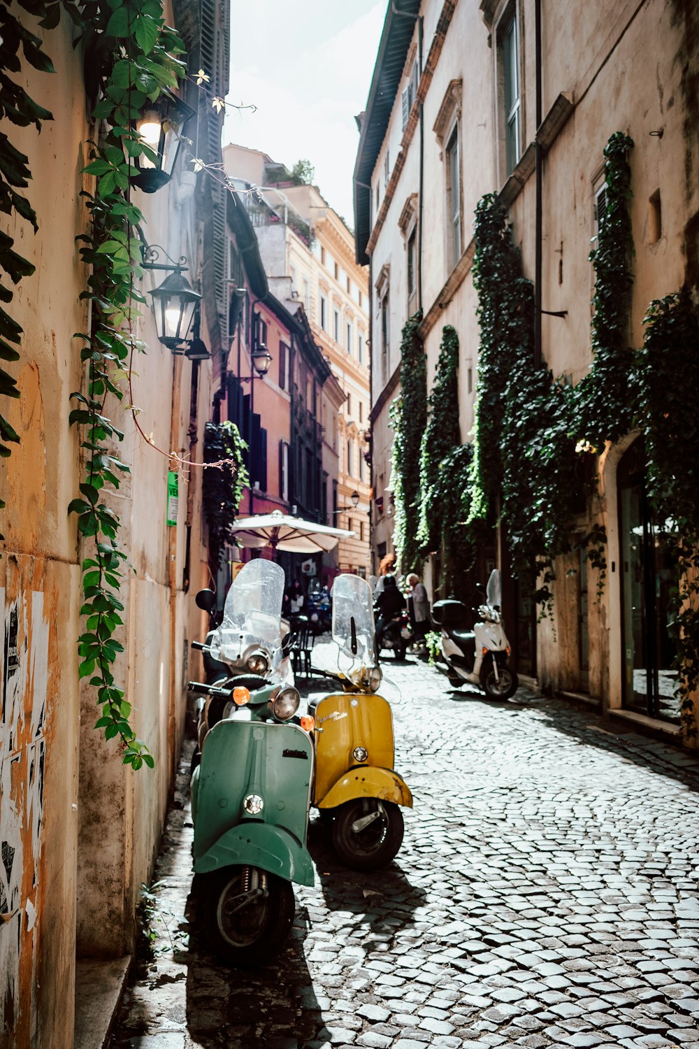 yellow and black motor scooter parked beside brown concrete building during daytime