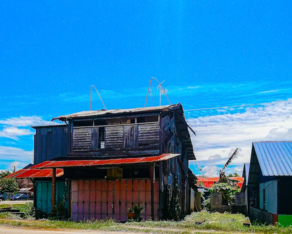 brown wooden house on green grass field under blue sky during daytime