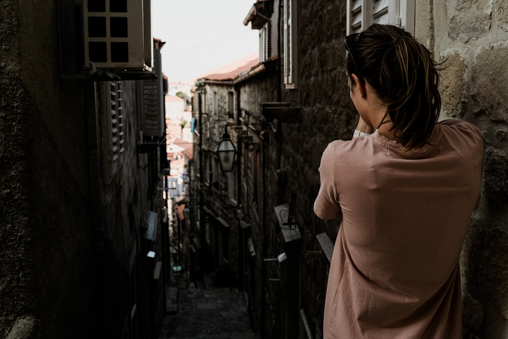 woman in brown dress standing on street during daytime