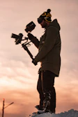 A content creator filming with a compact camera setup outdoors at golden hour