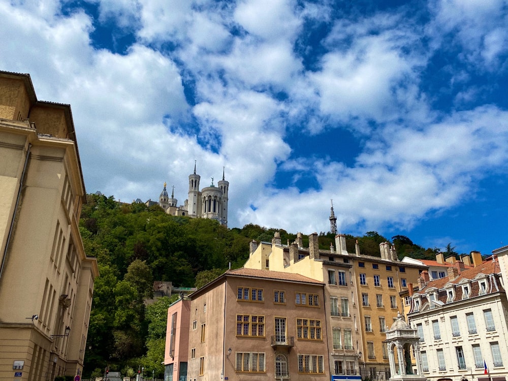 brown and white concrete buildings under blue sky and white clouds during daytime