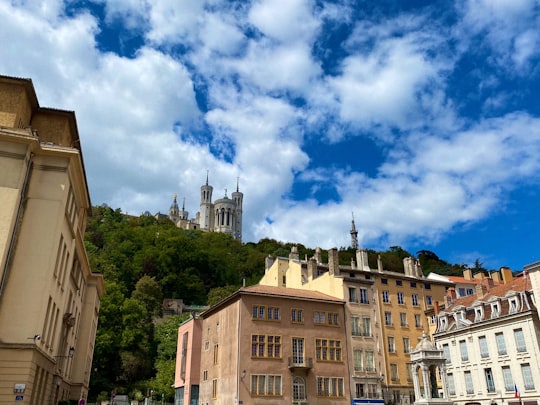 brown and white concrete buildings under blue sky and white clouds during daytime in Basilica of Notre-Dame de Fourvière France