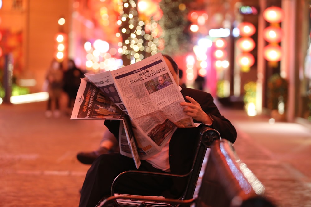 椅子に座って新聞を読む人