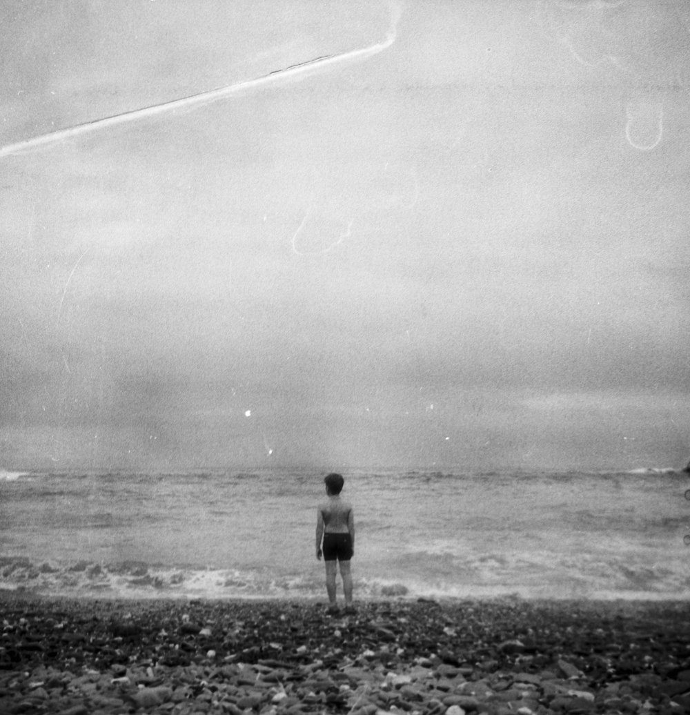 man in black shirt standing on seashore