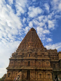 Volunteers and artisans collaborating on the temple's foundation with tools and blueprints.