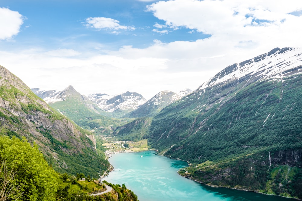 green and gray mountains beside river under blue sky during daytime