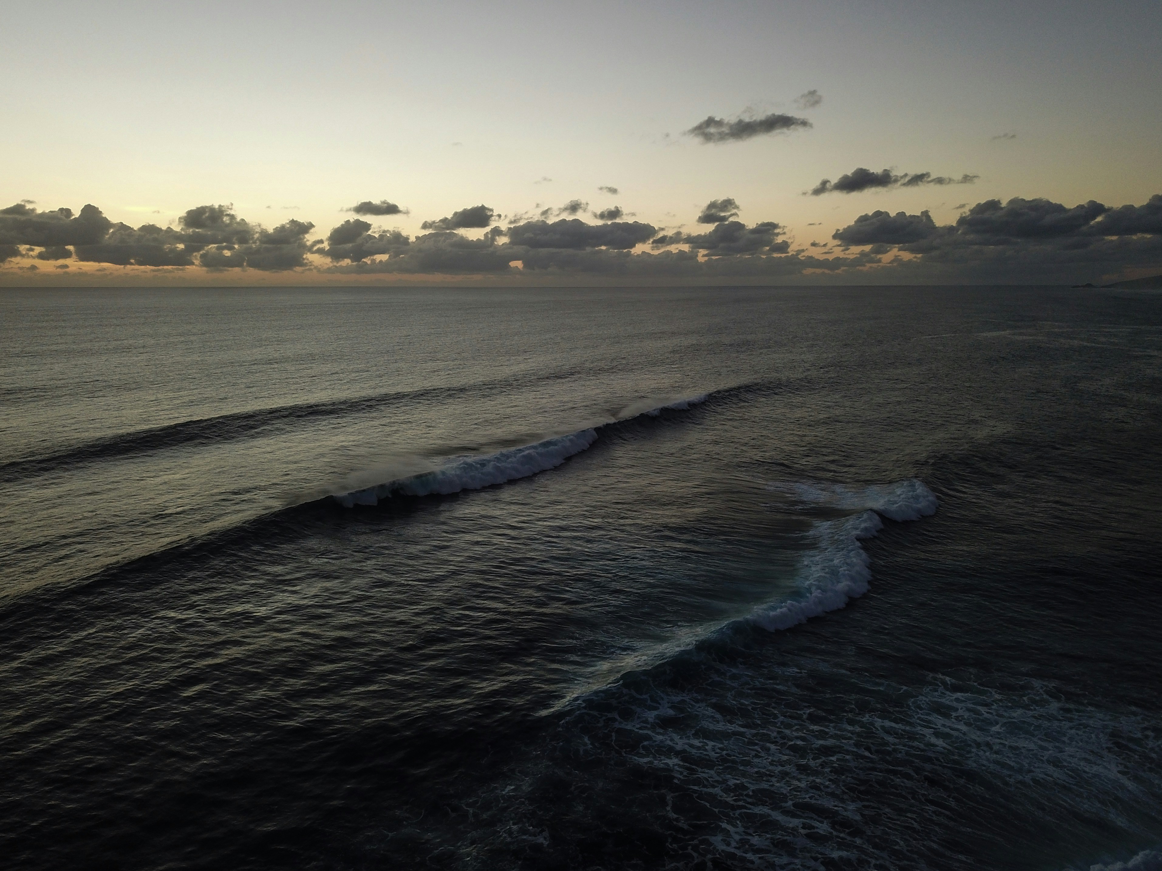 ocean waves crashing on shore during sunset