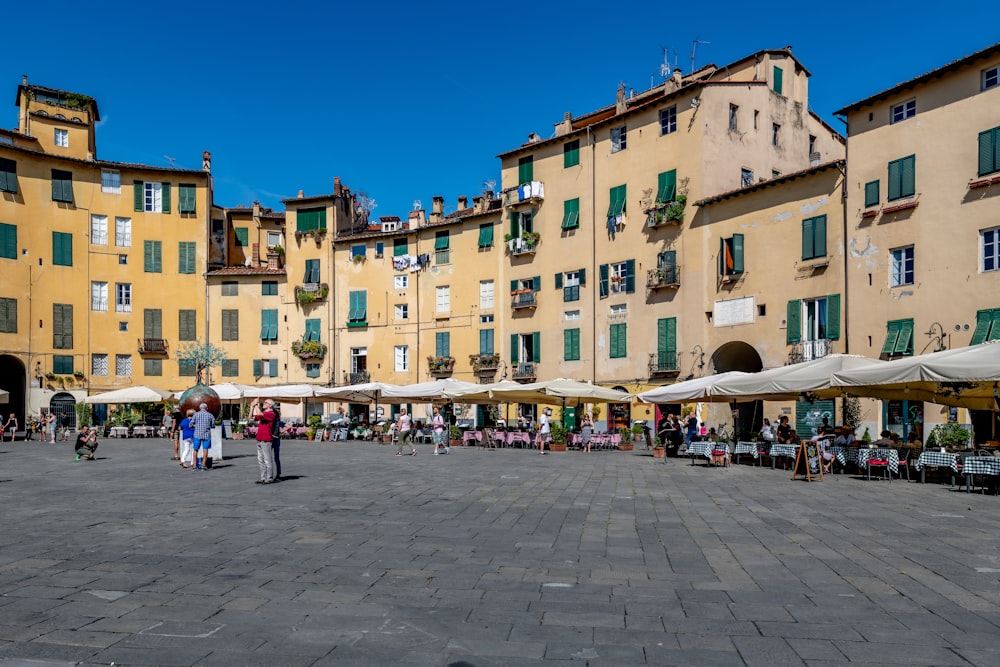 persone che camminano per strada vicino agli edifici durante il giorno