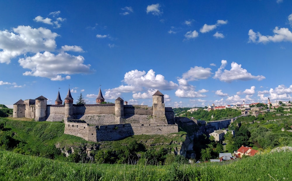 brown concrete castle under blue sky and white clouds during daytime