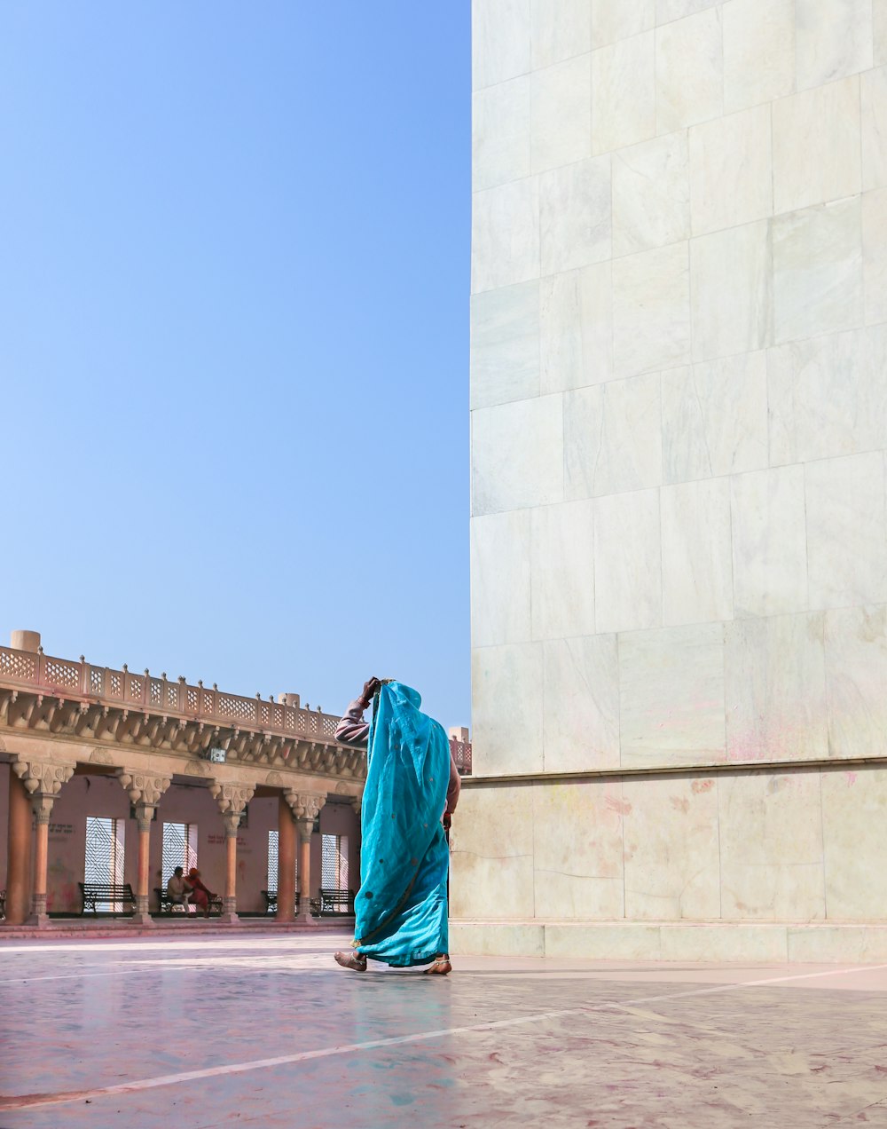woman in green hijab standing near white concrete building during daytime