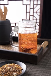 clear glass mug with brown liquid inside