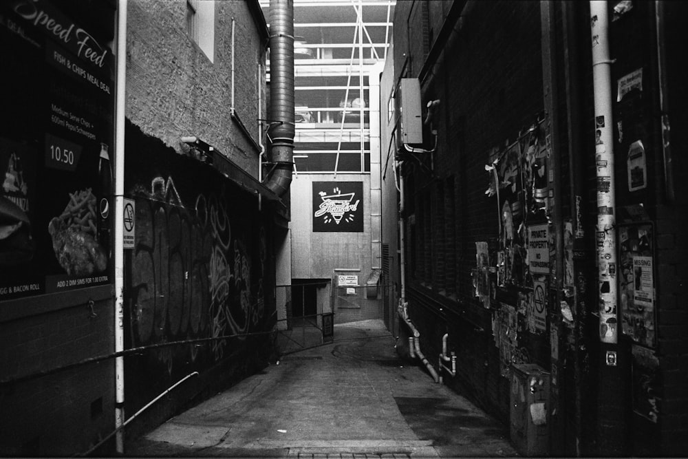 grayscale photo of hallway with graffiti