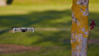 Drone spraying moss remover on a sloped roof under bright daylight.
